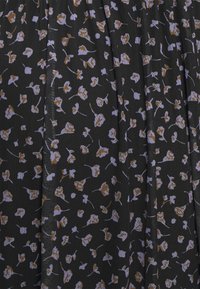 Svart tyg med ett blommönster som har små lavendel- och bruna blommor, med en strukturerad finish och veck.