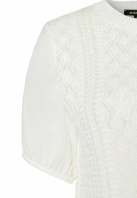 Weißes Strickoberteil mit strukturiertem Spitzenmuster am Oberteil und sanften Puffärmeln mit elastischen Bündchen. Leichter Stoff mit filigranen Details.