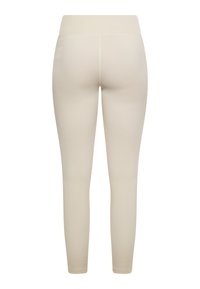 Beige leggings met een aansluitend ontwerp, gladde textuur en hoge tailleband. De achterkant heeft minimale stiksels en geen zichtbare logo's of patronen.