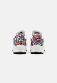 Sneakers featuring a vibrant, multi-colored graphic print on the sides, white mesh upper, and black rubber sole.