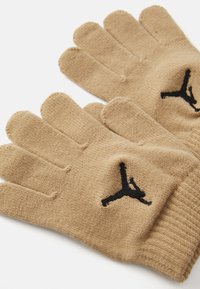 Par rukavice od bežnog pletenog materijala s crnim izvezenim Jumpman logom na zadnjoj strani svake ruke, položene ravno na beloj pozadini.