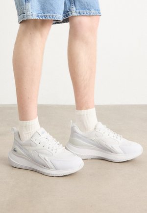 Bijele atletske tenisice s teksturiranim materijalom i glatkim detaljima, s udobnom potplatom i veznim dizajnom. Klasičan, minimalistički stil.