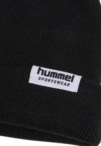 Zwarte gebreide beanie met een geribbeld patroon en een witte label met "hummel" en "SPORTSWEAR" in vetgedrukte zwarte letters.