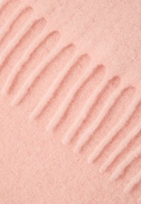 Světle růžová plsťová látka s texturovaným vzorem vystouplých pásků. Materiál působí měkce a je rovnoměrně texturovaný po celé ploše.