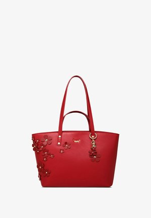 Červená kabelka z umělé kůže s květinovými aplikacemi, dvěma rukojeťmi a zlatým přívěskem. Hladká textura a strukturovaný design.