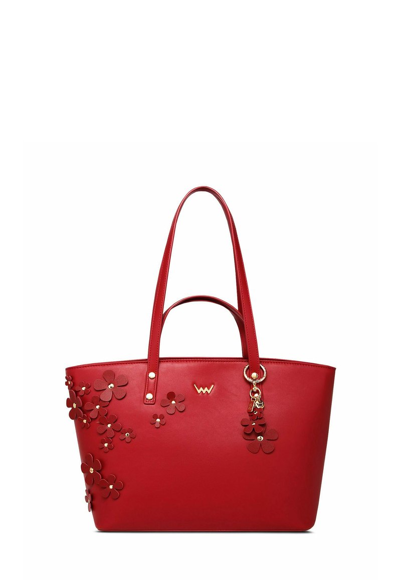 Červená kabelka z umělé kůže s květinovými aplikacemi, dvěma rukojeťmi a zlatým přívěskem. Hladká textura a strukturovaný design.