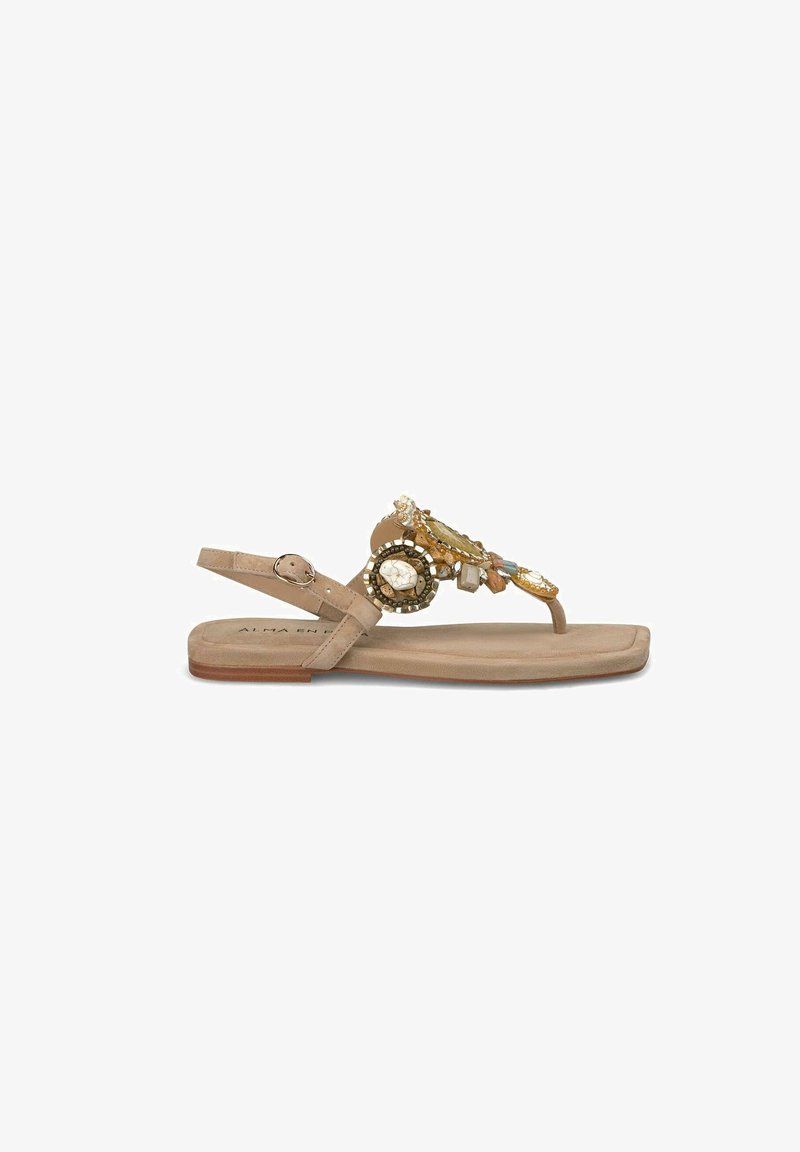 Beige Flachsandale mit verstellbarem Knöchelriemen, verziert mit dekorativen Juwelen und Perlen auf dem Obermaterial. Weich strukturierter Fußbett, minimalistisches Design.