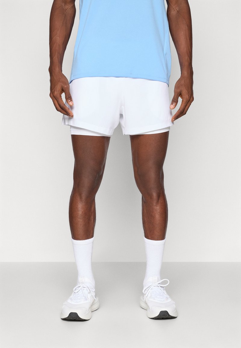 Maglietta atletica leggera blu chiaro abbinata a pantaloni corti bianchi. Sneakers e calzini bianchi completano il look. Tessuto morbido e design con vestibilità comoda.