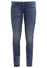 Úzké modré džíny vyrobené z denimu, s vybledlým vzhledem, pěti kapsami a zipem se zapínáním na knoflík.