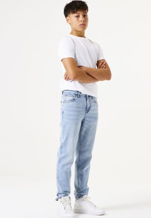 Lichtblauwe denim jeans met een straight-leg pasvorm, gecombineerd met een eenvoudig wit t-shirt en witte sneakers. Eenvoudig, casual ontwerp.