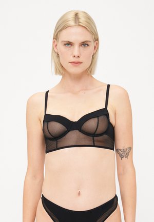 Zwarte lingerie bralette van doorschijnend gaas en stevige stof, met verstelbare banden, beugelsupport en een aansluitend ontwerp.