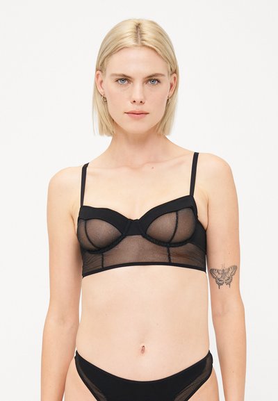 Black lingerie bralette with sheer mesh and solid fabric cups, featuring adjustable straps, underwire support, and a fitted design.