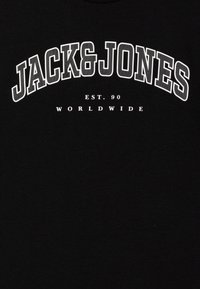 Crna majica s kratkim rukavima koja sadrži bijeli natpis: "JACK&JONES" u luku, s natpisom "EST. 90 WORLDWIDE" ispod u manjim slovima. Mekani pamučni materijal.