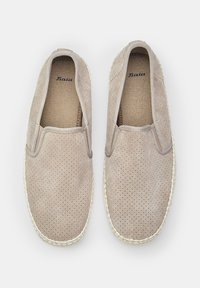 Beige slip-on espadrille, perforált nubukból készült felsőrésszel, szőtt juta díszítéssel a talp körül, és textúrázott szövet bélés.