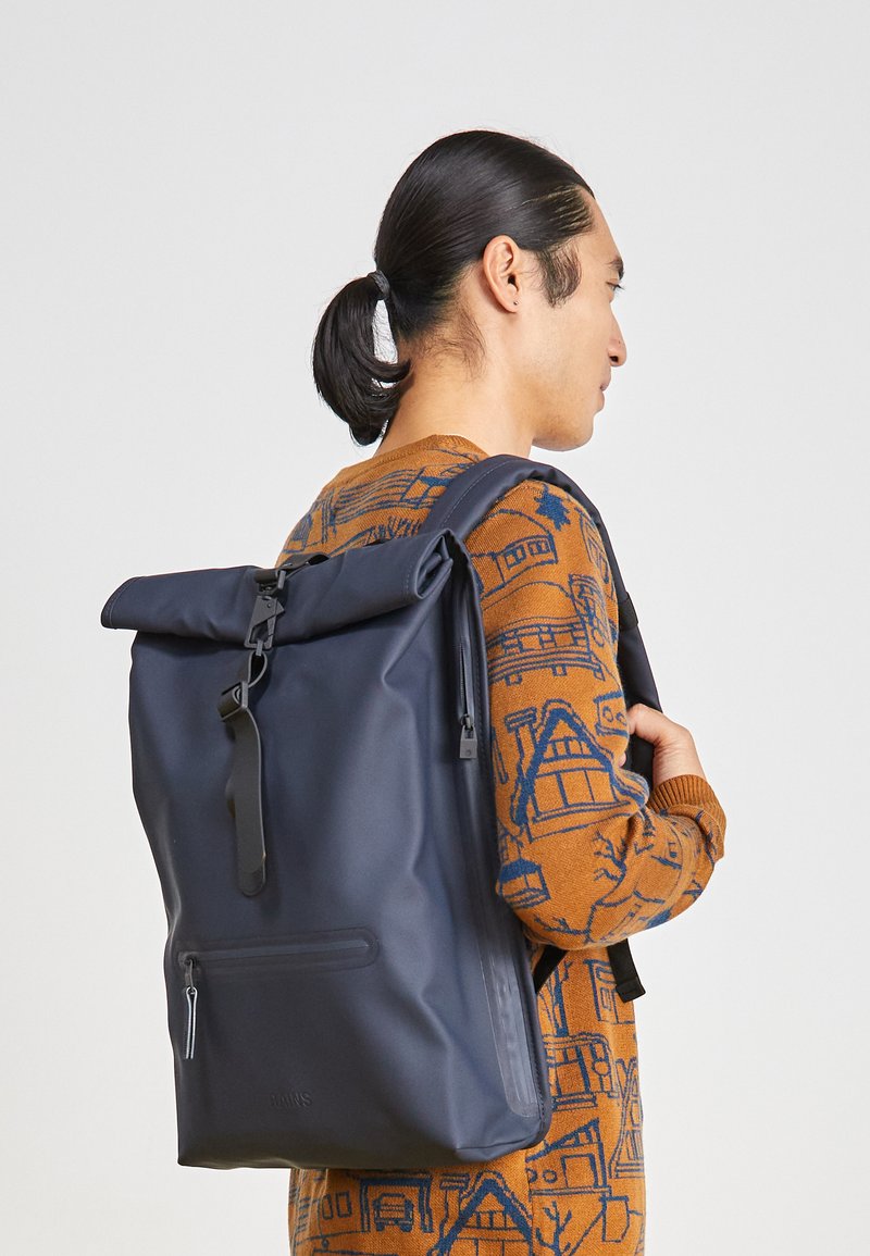 rains backpack roll top Rolltop Rucksack - Waterproof with Chest Strap, Standard | Iconic roll-top with snap compression and carabiner closure, front zip pocket, side-access slip pocket and vented back while the side pockets and signature carabiner hook offer additional storage options RAINS Rolltop Rucksack - Green
