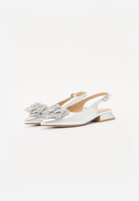 Silberne Slingback-Schuhe mit spitzem Zeh, verziert mit einem perlenbesetzten floralen Akzent und einem niedrigen, klobigen Absatz. Glatte, metallische Oberfläche.