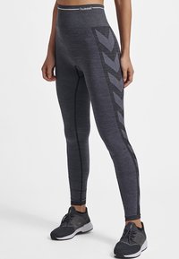 Legginsy z wysokim stanem, dopasowane, w ciemnoszarym kolorze, z czarnym printem w zygzak wzdłuż boku oraz kontrastującymi detalami w stichingu.