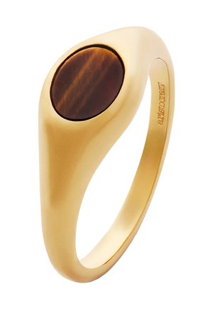 Anillo en tono dorado con una piedra marrón ovalada incrustada. Banda lisa y redondeada con un acabado pulido. Diseño minimalista y moderno.