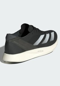 Schwarzer Sportschuh mit strukturiertem Obermaterial, weißen Streifenakzenten und einer hellgrauen Zwischensohle, die mit "LIGHTSTRIKE PRO" beschriftet ist.