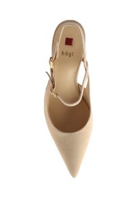 Beige suède hoge hak schoen met een puntige neus, enkelbandje en goudkleurige gesp. Heeft een glad interieur met een logo van het merk.