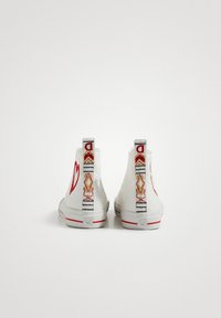 White high-top sneakers with red heart embroidery, patterned backstrip featuring geometric designs, rubber soles, and red accents.