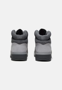 Grijze buitenschoenen met een gladde rubberen zool, een gestructureerde bovenkant en een zachte, ronde kraag voor comfort. Beschikt over een slank, modern ontwerp.