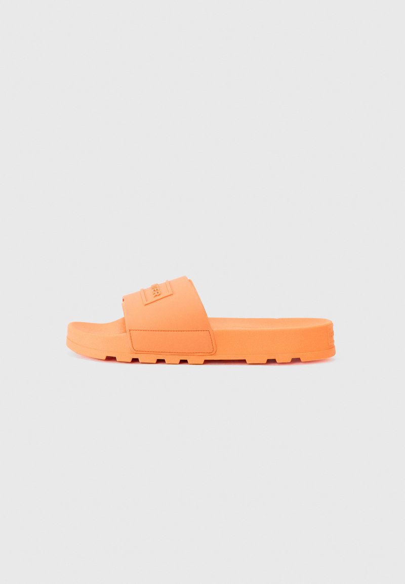 Orange gummisandal med en bred rem, strukturerad yta och en platt sula med ett räfflat mönster för bra grepp.