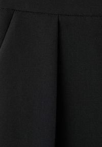 Schwarzer Stoff mit glatter Textur, ausgestattet mit Falten für zusätzliche Dimension. Der Stoff wirkt leicht und eignet sich für verschiedene Designs.