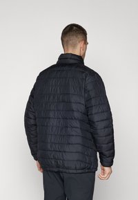 Giacca nera imbottita con colletto alto, caratterizzata da un design trapuntato e polsini elasticizzati, vista dal retro.