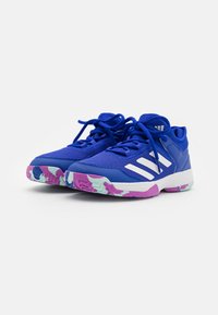 Scarpe atletiche blu in materiale mesh con strisce bianche, dotate di una suola testurizzata viola e menta. I lacci sono allacciati.