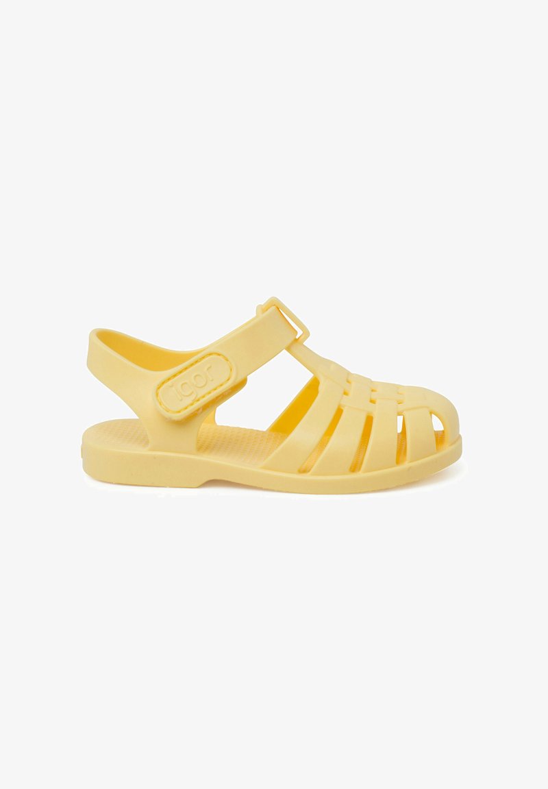 Gele plastic sandalen met een open teenontwerp, meerdere uitsparingen, een verstelbare band en een gestructureerde zool voor grip. Merkenlogo zichtbaar.