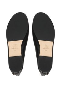 Paire de ballerines en cuir noir montrée par les semelles, avec un avant-pied et un talon en caoutchouc noir lisse, et une semelle intermédiaire en cuir beige portant la mention "Cuir véritable" taille 37.