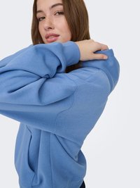 Lichtblauwe hoodie van zachte stof met een ontspannen pasvorm. Voorzien van een zak aan de voorkant, geribbelde manchetten en een capuchon met trekkoord.