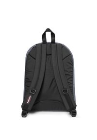 Mochila negra con correas ajustables acolchadas, respaldo plano y un asa en la parte superior. Fabricada con un material duradero de textura suave.