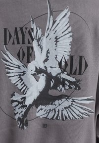 Gray sweatshirt featuring a large graphic of two doves, with black text reading "DAYS OF OLD" and a circular line accent.