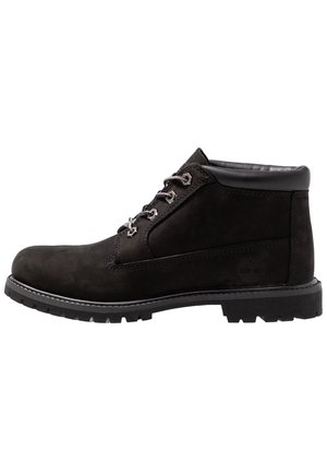 Schwarze Wildleder-Ankle-Stiefel mit abgerundeter Zehe, kontrastierenden weißen Nähten und Metallösen; Gummisohle mit Profil für besseren Halt.