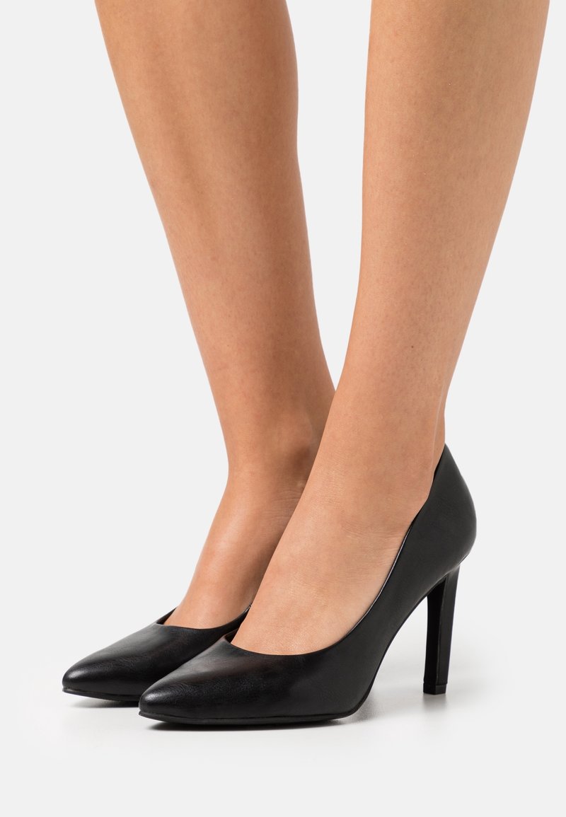 Escarpins noirs à talons hauts en cuir lisse, dotés d'un bout pointu et d'un talon fin, au design simple et épuré.