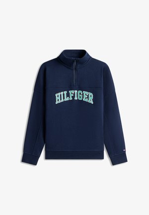 Marineblauwe trui met een kwart-ritsnek, met "HILFIGER" in een geborduurde boog over de voorkant. Zachte textuur en geribbelde manchetten.