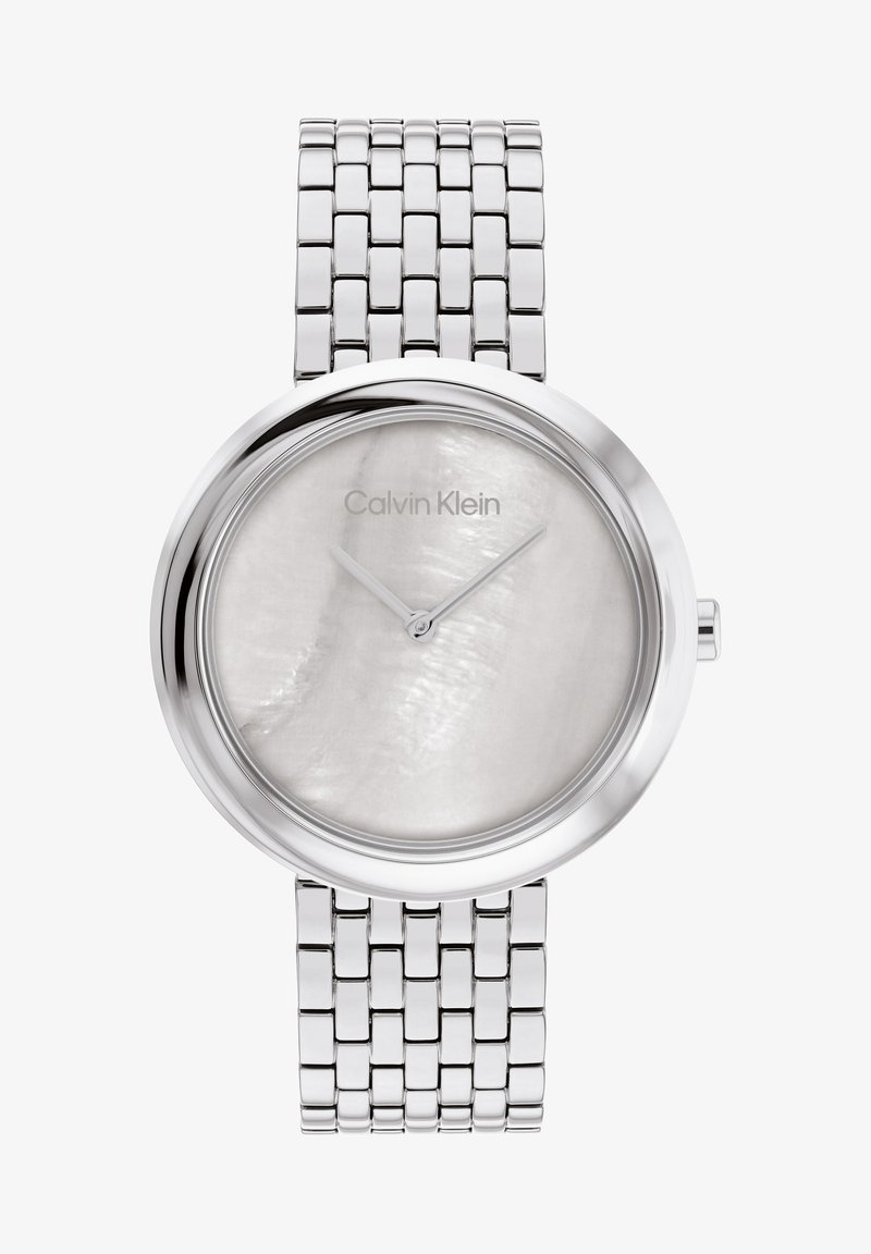 Sølvfarget metallklokke med rund kasse, hvit perlemorsskive, tynne sølvhender og vevd rustfritt stålarmbånd.