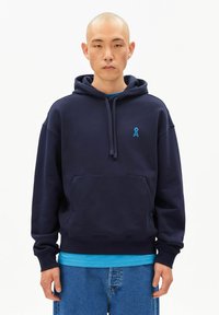 Marineblauwe hoodie met een voorvak in kangoeroestijl, een capuchon met trekkoord en een turquoise lintlogo op de borst. Zachte textuur en casual pasvorm.