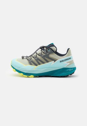 Scarpa da trail running Salomon con una toma leggera blu e grigia, accenti neri, un sistema di allacciatura rapida e una suola testurizzata in giallo e verde.