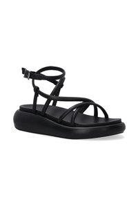 Schwarze Riemchensandalen mit einer flachen, gepolsterten Sohle. Hergestellt aus glattem Material, mit mehreren kreuzweise angeordneten Riemen und einer verstellbaren Knöchellasche.