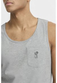Top din material moale, gri deschis, cu un mic design brodat ce reprezintă o băutură cu o felie de lămâie pe buzunarul din stânga.
