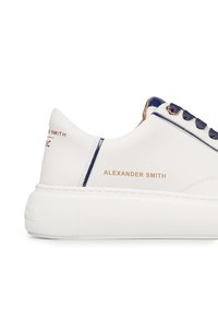 Weiße Leder-Sneaker mit navyblauen Akzenten, strukturiertem Sohlenprofil und goldener Markenkennzeichnung. Mit runden Schnürsenkeln und einer glatten Oberfläche.
