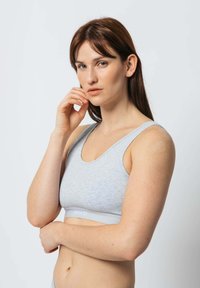 Grauer Sport-BH mit rundem Ausschnitt und breiten Trägern. Aus weichem, strukturiertem Stoff gefertigt, mit einem kontrastierenden elastischen Band, das "SNOCKS" zeigt.