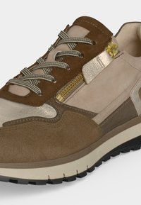 Baskets en daim beige et marron avec lacets rayés, fermeture éclair latérale dorée et semelle en caoutchouc texturée pour un usage décontracté.