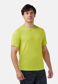 Kortærmet limegrøn sportstrøje, letvægtsstof, rund halsudskæring, raglanærmer, med et lille logo på venstre arm.