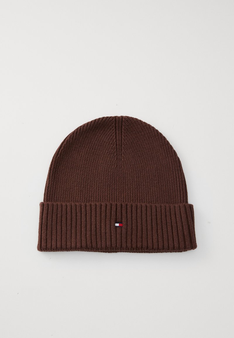 Bonnet en tricot marron avec un revers côtelé. Présente un petit logo brodé en bleu, blanc et rouge sur le devant. Texture douce.
