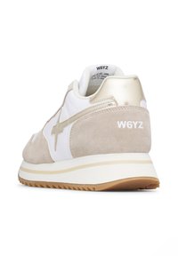 Beige and white sneaker with a suede upper, metallic gold accents, and a thick white rubber sole. Features a decorative star on the side.