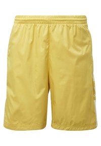 Gula idrottsshorts med resårmidja, tillverkade av lätt material, med sidostrecker och en slät yta.